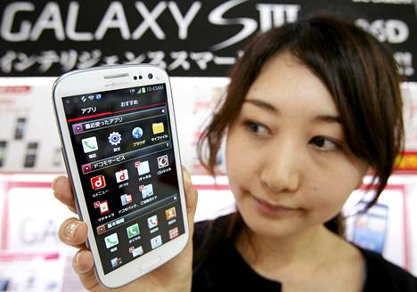 Myyjä esitteli Samsungin Galaxy S III -älypuhelinta elektroniikkaliikeessä Tokiossa kesäkuussa. 