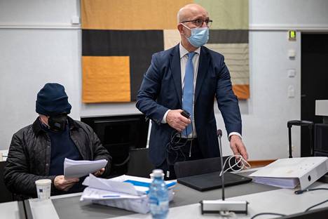 Murhasta tuomittu mies käräjäoikeudessa joulukuussa 2021. Oikealla asianajaja Heikki Uotila. 