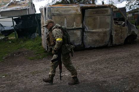Ukrainalaissotilas kävelee Venäjältä takaisin vallatussa kylässä Harkovan pohjoispuolella 15. toukokuuta.