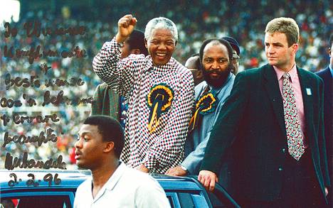 Henkivartija Etienne van Eck (oik.) suojeli presidentti Nelson Mandelaa joukkokokouksessa Etelä-Afrikassa. Kuvan päälle Mandela on kirjoittanut kiitoksensa henkivartijalleen.