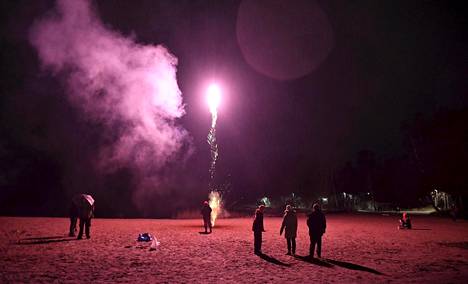 Ihmisiä oli kerääntynyt rannalle ampumaan ilotulitteita vuoden vaihtumisen kunniaksi Lauttasaaressa Helsingissä uudenvuodenaattona torstaina.