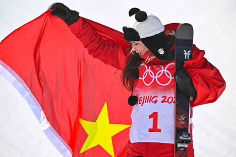 Eileen Gu poseerasi Kiinan lipun kanssa olympialaisissa.