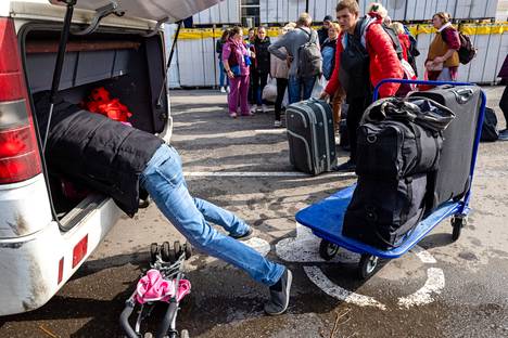 Vsevolod Ivanov punaisessa takissa ja muut pakolaiset tunkevat laukkujaan Mustanmeren suuntaan lähtevään bussiin. 