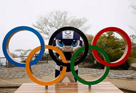 Tokion olympialaisten maskotti Miraitowa poseerasi olympiarenkaitten takana keskiviikkona, kun kisojen alkuun on sata päivää.