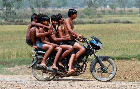 Pojat ajoivat moottoripyörällä uimasta Chachuran kylässä Intiassa. YK:n ennusteen mukaan Intian väkiluku on 15 vuoden kuluttua jo 1,45 miljardia.