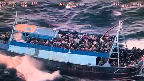 Kuvakaappaus Italian rannikkovartioston julkaisemasta videosta, jossa näkyy ylikuormitettu vene Välimerellä.