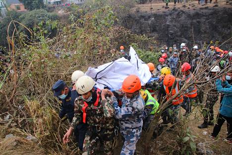 Pelastustyöntekijät etsivät lentoturman uhreja Pokharassa, Nepalissa maanantaina. 