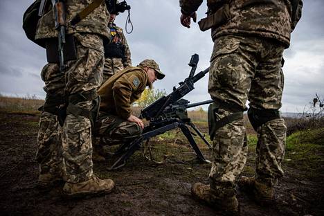 Ukrainalaissotilaat tarkistavat aseidensa toimintaa eturintamassa Donetskin alueella 24. lokakuuta.