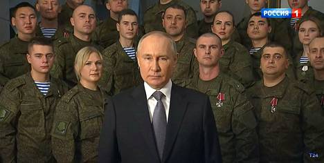 Вместо Кремля фоном у Путина теперь солдаты. Скриншот с ТВ-экрана.