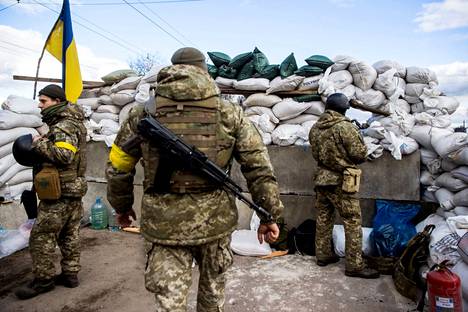 Ukrainalaissotilaita hiekkasäkkien ympäröimällä tarkistuspisteellä Žytomyrissa.