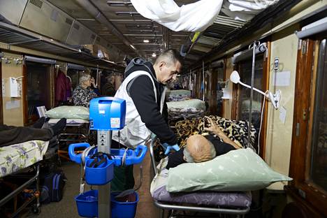 Медбрат Андрей Кораблин меряет пациенту давление. Фото: Юха Салминен / HS
