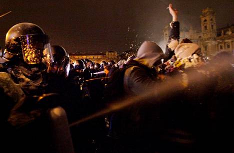 Mellakapoliisi käytti kyynelkaasua mielenosoittajia vastaan parlamenttitalon edustalla Budapestissa perjantaina.