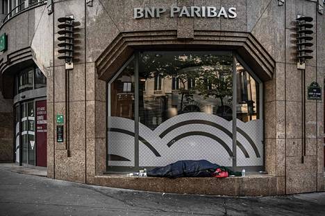 Asunnoton nukkui pankin ikkunasyvennyksessä liikkumisrajoitusten hiljentämässä Pariisissa 16. huhtikuuta.