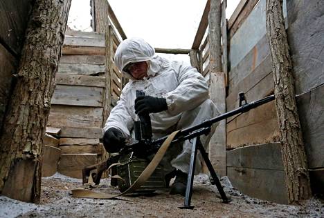 Venäjän tukeman niin sanotun Donetskin kansantasavallan taistelija tarkisti konekiväärinsä kuntoa Itä-Ukrainassa perjantaina.
