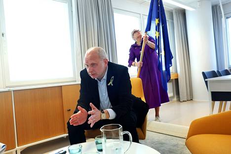 EU:n Ukrainan lähettiläs Matti Maasikas antoi haastattelun Euroopan komission edustustossa Helsingissä. Edustuston apulaispäällikkö Maria Kokkonen asentaa EU-lippua taustalle.