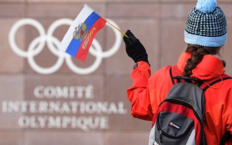 Venäjän fani heilutti maan lippua Kansainvälisen olympiakomitean KOK:n pääkonttorin ulkopuolella Sveitsin Lausannessa.