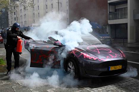 Tässä sammutetaan ”tavallista” autopaloa. Tesla sytytettiin tuleen Ranskan Rennesissä eläkeuudistusta vastustavissa mielenosoituksissa. 