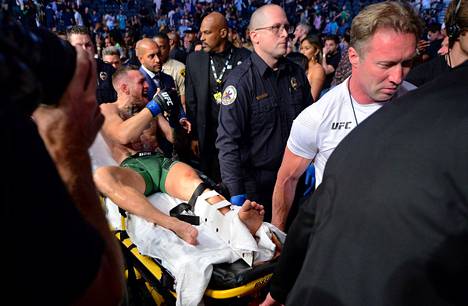 Conor McGregor kannettiin paareilla pois, kun hänen vasen sääriluunsa murtui Las Vegasin ottelussa.