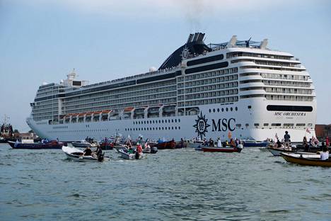 Venetsialaiset protestoivat kuljettaen omia veneitään laguunin läpi kulkevan risteilyaluksen vierellä kesäkuussa.