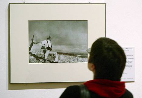 Berliiniläinen näyttelykävijä katsoo Robert Capan kuuluisaa valokuvaa Kaatuva sotilas vuodelta 1936. Espanjan sisällissodan aikainen valokuva esittää kuolevaa tasavaltalaissotilasta, mutta kuvan aitous on herättänyt sittemmin keskustelua.