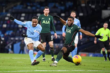 Manchester Cityn Raheem Sterling laukoo maalille, Tottenham Hotspursin Japhet Tanganga yrittää blokata.