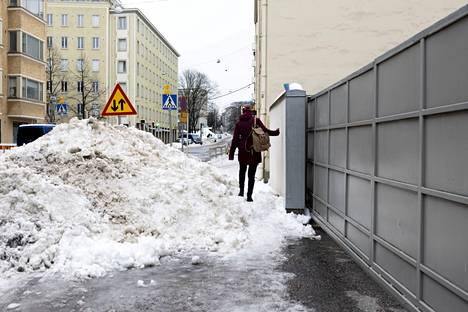 Jalankulkijat joutuivat kipuamaan lumikasan yli Töölössä maanantaina.