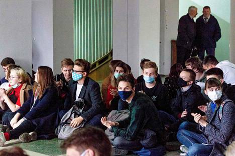 Lakkoilevat opiskelijat istuivat maanantaina yliopiston lattialla Minskissä.