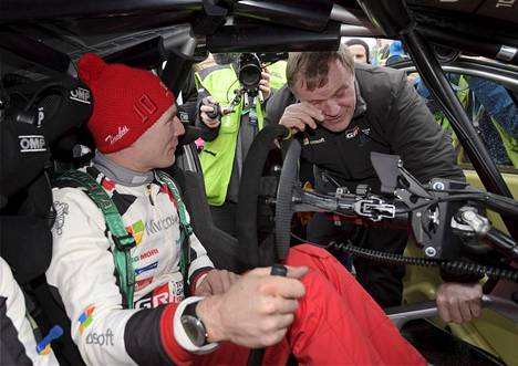 Jari-Matti Latvala katsoo vieressä, kun tallipäällikkö Tommi Mäkinen herkistelee Toyotan ensimmäistä palkintopallisijoitusta.