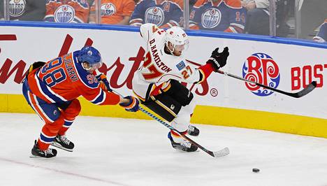 Edmonton Oilersin suomalaishyökkääjä Jesse Puljujärvi ja Calgary Flamesin puolustaja Dougie Hamilton taistelevat kiekosta NHL-ottelussa Edmontonissa.