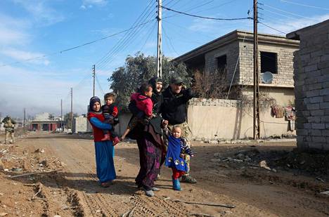 Irakin armeijan sotilas ohjasi pakenevia ihmisiä Itä-Mosulissa torstaina.