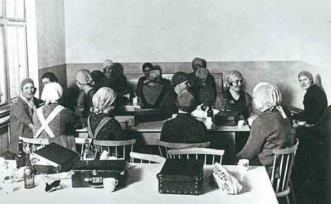 Hämeenlinnan verkatehtaan työläiset söivät lounaaksi omia eväitä tehtaan konttorirakennuksessa. Kuva on todennäköisesti 1930-luvulta.