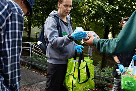 Päihdetyöntekijä Juhani Vihervä ojentaa Kinaporinpuiston kulmalla ruokapakkauksia huumeiden käyttäjille ja asunnottomille.