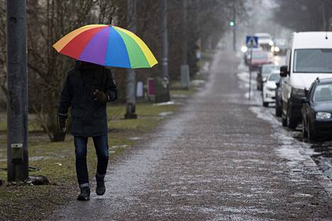 Jalankulkija harmaassa sadesäässä Koskelantiellä Helsingissä 17. helmikuuta.