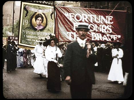 Väritettyä arkistokuvaa nähdään muun muassa suffragettien mielenosoitusmarsseilta.