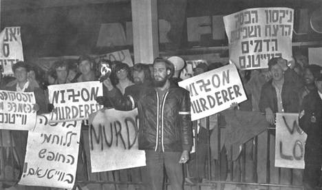 Amerikkalainen mielenosoittaja polttaa passinsa Yhdysvaltain lähetystön edustalla Tel Avivissa keskiviikkona järjestetyssä mielenosoituksessa. Satakunta mielenosoittajaa kantoi kylttejä, joissa luki "Nixon murhaaja". Israelin lisäksi järjestettiin Pohjois-Vietnamin pommitusten vastaisia mielenosoituksia keskiviikkona myös mm. Jugoslaviassa.