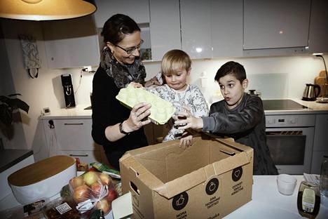Sukupolvien korttelissa asuvat Elina, 40, Emil, 3, ja Timo Salzwedel, 10, purkivat ruokalähetystä kotonaan Jätkäsaaressa.