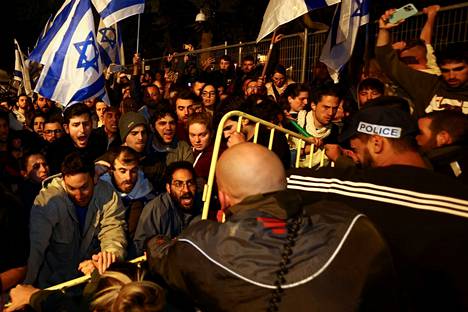 Mielenosoittajia ja poliiseja pääministerin virka-asunnon edustalla Jerusalemissa sunnuntaina.