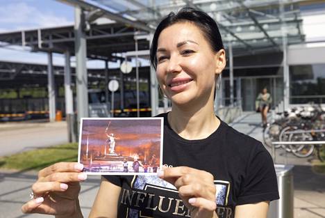 Юлия Кочетова from Volgograd came to Finland for her own wedding.  In her hands – an postcard with the image of a statue «Родина-мать зовёт!».  Photo: Yukha Metso