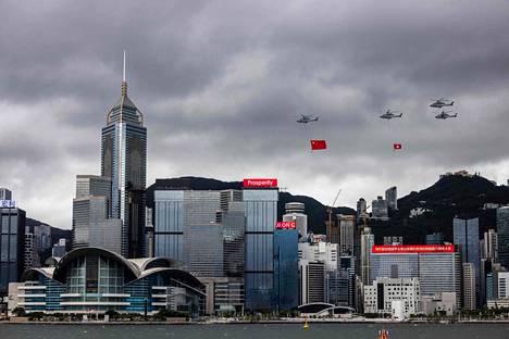 Helikopterit lensivät perjantaina Hongkongin yllä riiputtaen Kiinan ja Hongkongin lippuja.