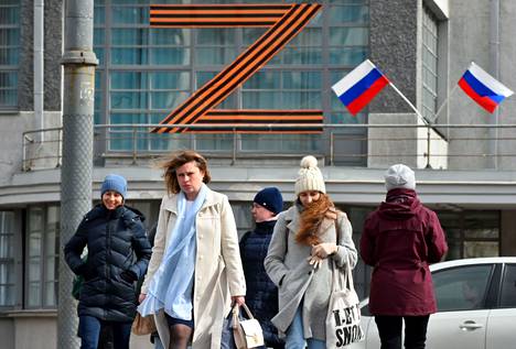 Ihmisiä kulki Venäjän hyökkäyssotaa tukevilla symboleilla koristellun rakennuksen ohi Venäjän Pietarissa 4. huhtikuuta.