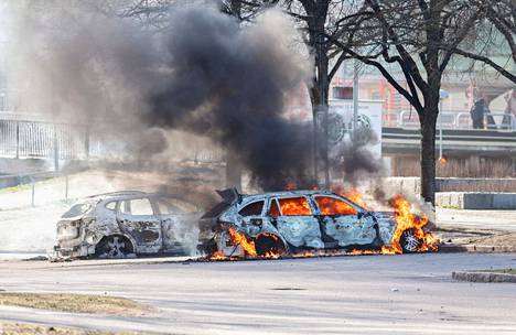Autot paloivat pysäköintialueella Ruotsin Norrköpingissä sunnuntaina, kun kaduilla oli alettu mellakoida äärioikeistolaisten järjestämää tapahtumaa vastaan.
