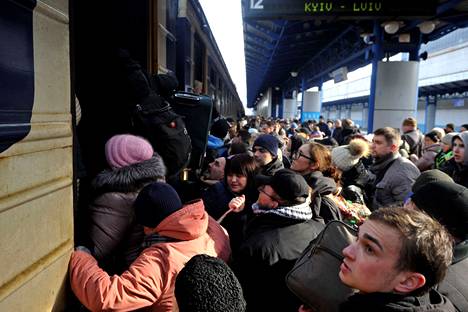 Ihmiset pyrkivät pois Kiovasta rautateitse perjantaina.