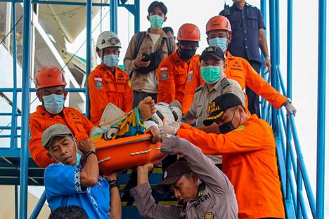 Pelastustyöntekijät kantoivat Serasanin saarella maavyöryssä loukkaantunutta alas laivasta. Laiva toi sairaalahoitoa tarvitsevia Länsi-Kalimantan
iin.