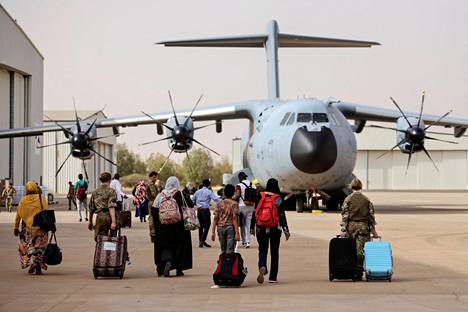 Britannian kansalaisia nousemassa evakuointikoneeseen Wadi Seidnan lentotukikohdassa keskiviikkona.