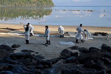 Kalastajat keräävät säiliöaluksesta vuotanutta öljyä rannalta Polassa Oriental Mindoro -maakunnassa Filippiineillä 22. maaliskuuta. 