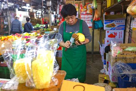 Myyjä kuori ananasta maaliskuussa Taipeissa Taiwanissa, josta kiellettiin ananasten vienti Manner-Kiinaan.