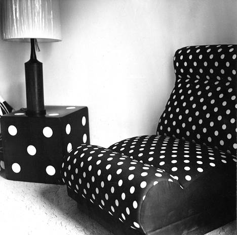 Valkoisia pilkkuja mustalla pohjalla, yöpöytään ne on maalattu, tuoliin painettu kankaalle. Moderni pirteä yhdistelmä eräästä Habitatin näyttelyasunnosta.