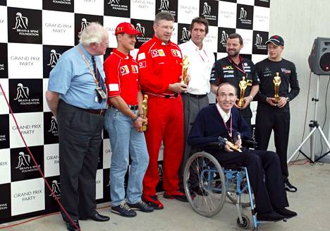 McLarenin F1-kuski Kimi Räikkönen (oik.) sai vastaanottaa yhdessä muun muassa Frank Williamsin ja Michael Schumacherin kanssa Bernie-patsaan osana Bernie Ecclestonen hyväntekeväisyyskampanjaa syyskuussa 2002.