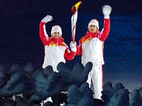 Dinigeer Yilamujiang (vas.) vilkutteli olympiasoihdun kanssa Pekingin olympialaisten avajaisissa.