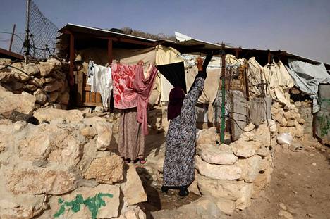 Nainen ripustaa vaatteita 9. toukokuuta palestiinalaisessa Jinbassa, Masafer Yattan alueella Länsirannalla, jossa israelilaistuomioistuimet hääsivät tuhat palestiinalaista rakentamansa armeijan tukikohdan tieltä. 
